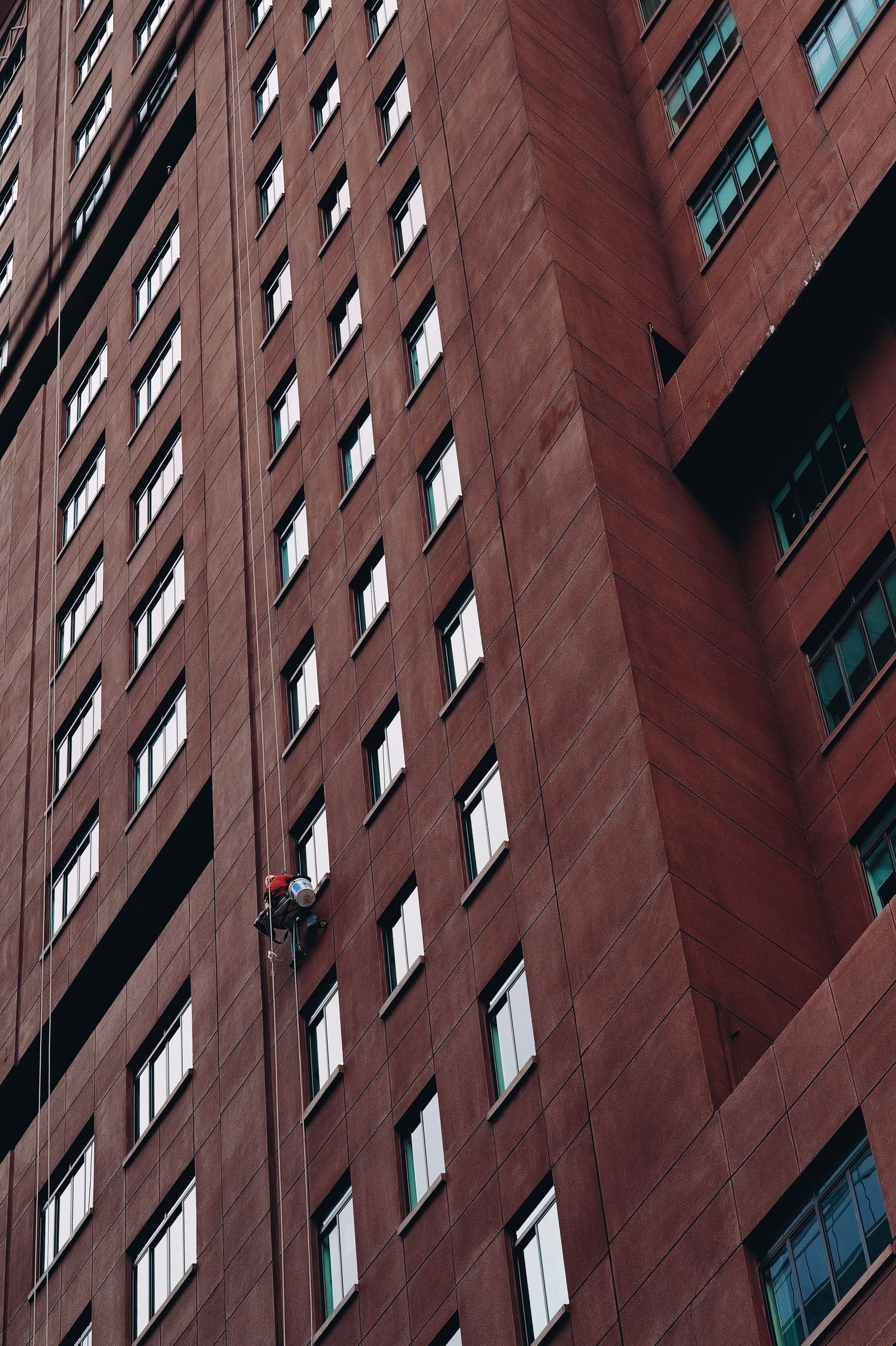 High-access technician working on the exterior of a multistory building